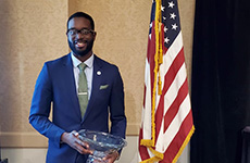 Ike Ejikeme in 2022, in front of the U.S. flag