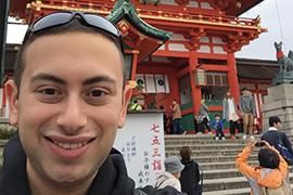 Joshua in 2018, taking a selfie in front of a temple