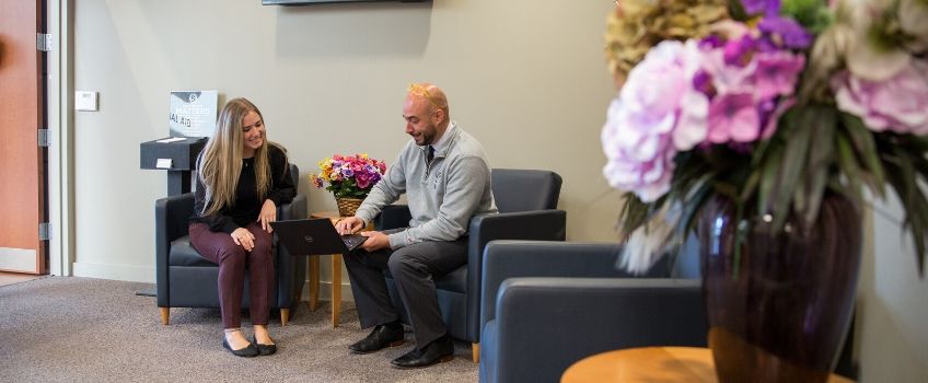man helping woman at computer