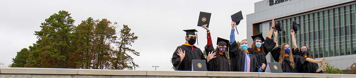 Graduates celebrating by wall