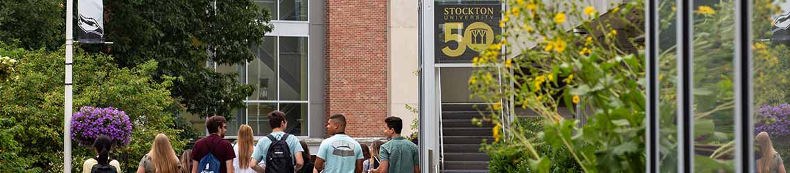 Students along College Walk with 50th anniversary banner