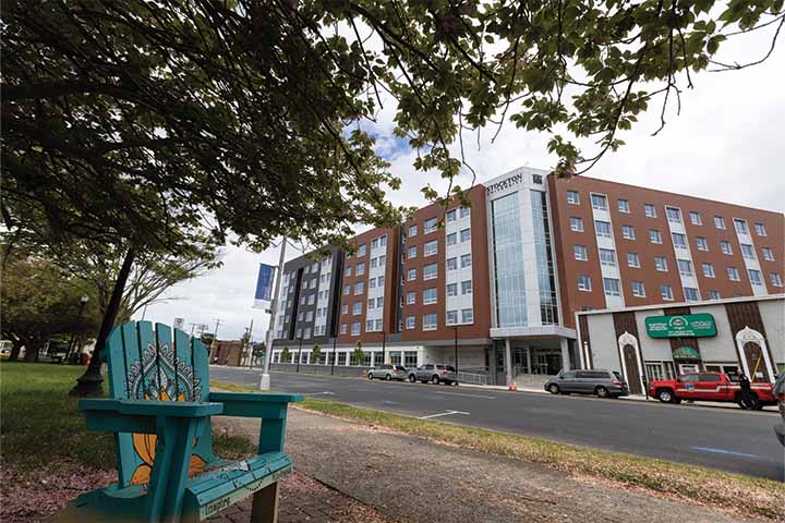 A green chair in the foreground of a view of the new residential building