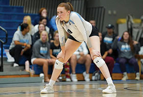 Kate Louer waits with hands on knees for volleyball serve