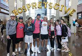 Group of students with Osprey Gives balloon arch