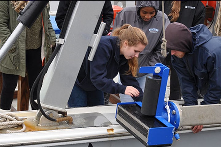 Students working with research equipment on a boat