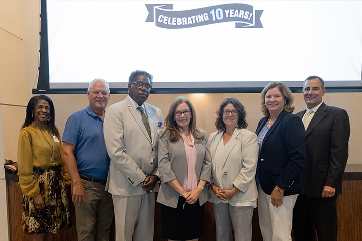 A group photo of seven administrators at the 10th anniversary celebration