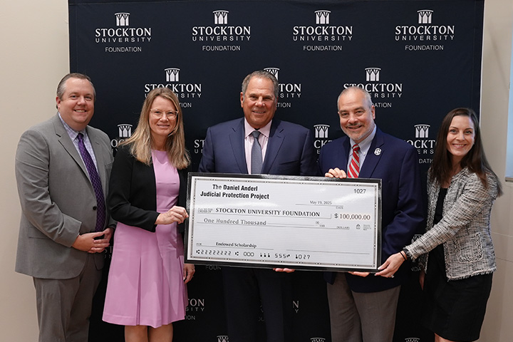 Donors hold a large check denoting their scholarship