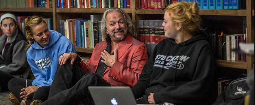 professor interacting with students in the library