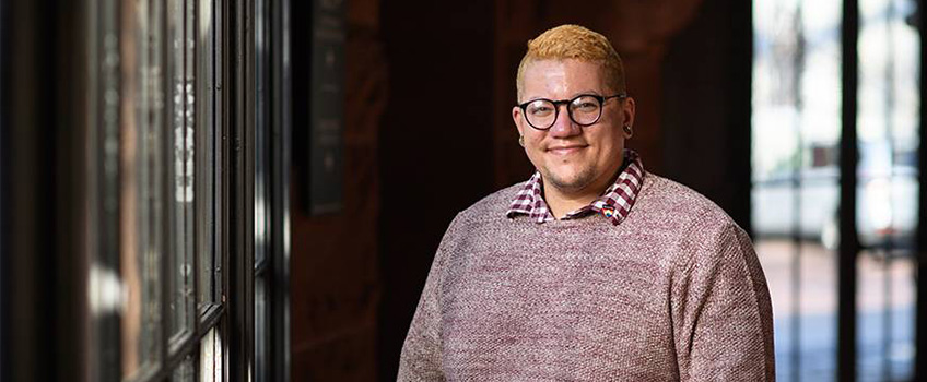 Eric Anglero standing indoors near windows