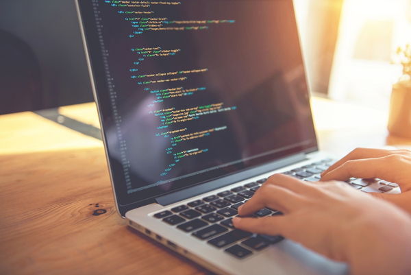 Student typing code into a computer