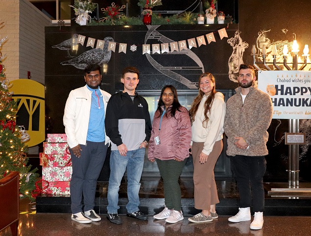 Student Advisory Board Members post in front of the Campus Center Fireplace