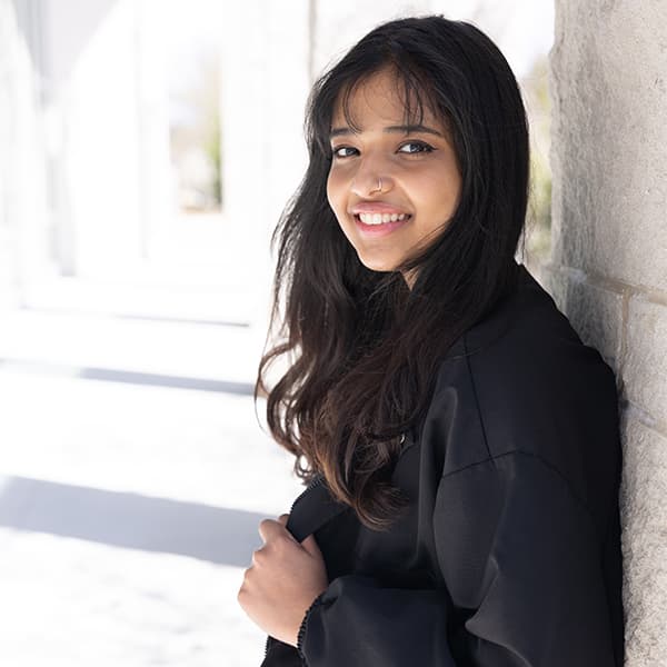 Nikitha Mohan standing outside of the Campus Center with her back against a wall