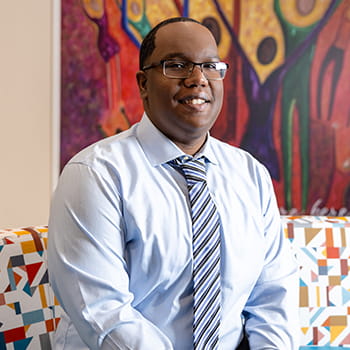 Troy Edwards sitting in the Multicultural Center, smiling for the camera