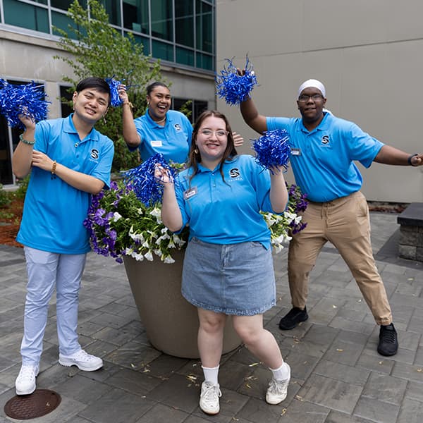 Troy Edwards (and friends) outside of the Multicultural Center, holding and shaking pompoms