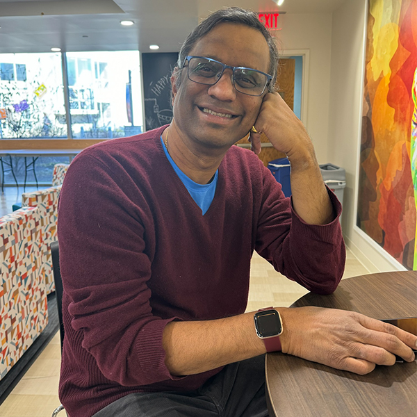 Faculty member Renganathan Iyer sitting in the Multicultural Center, smiling for a photo