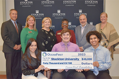 Scholarship recipients holding a check with President Joe, EVP Sass, and OceanFirst members