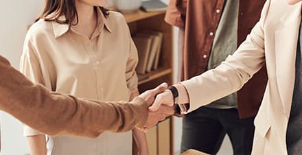 Stock image of people meeting each other, a handshake in the middle