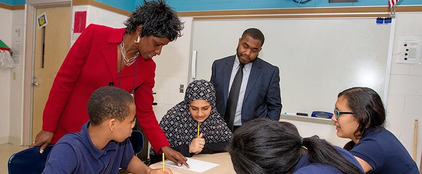 K-12 students and a teacher learning in a classroom