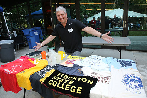 alumni at a table with Spring Bash and Stockton t-shirts