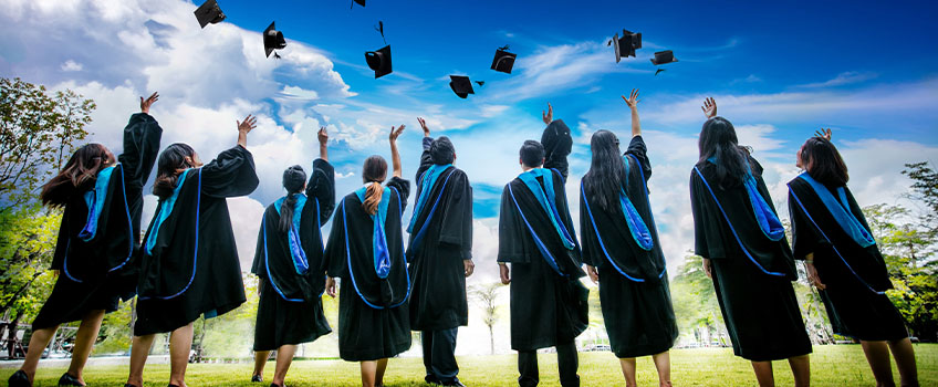 Students throwing their graduation caps into the air.