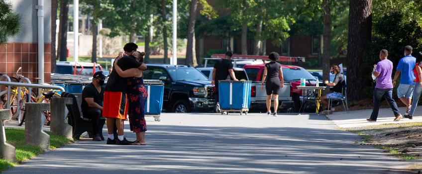 a student and family member hug on move-in day
