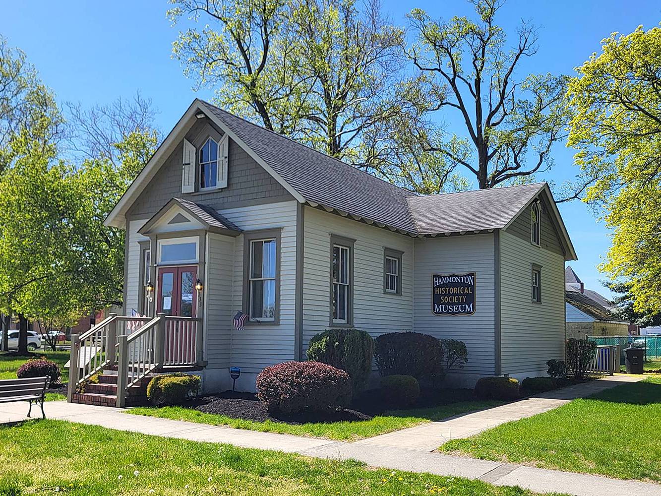 Historic building surrounded by greenery and grass. Plaque on building says "Historical Society of Hammonton"