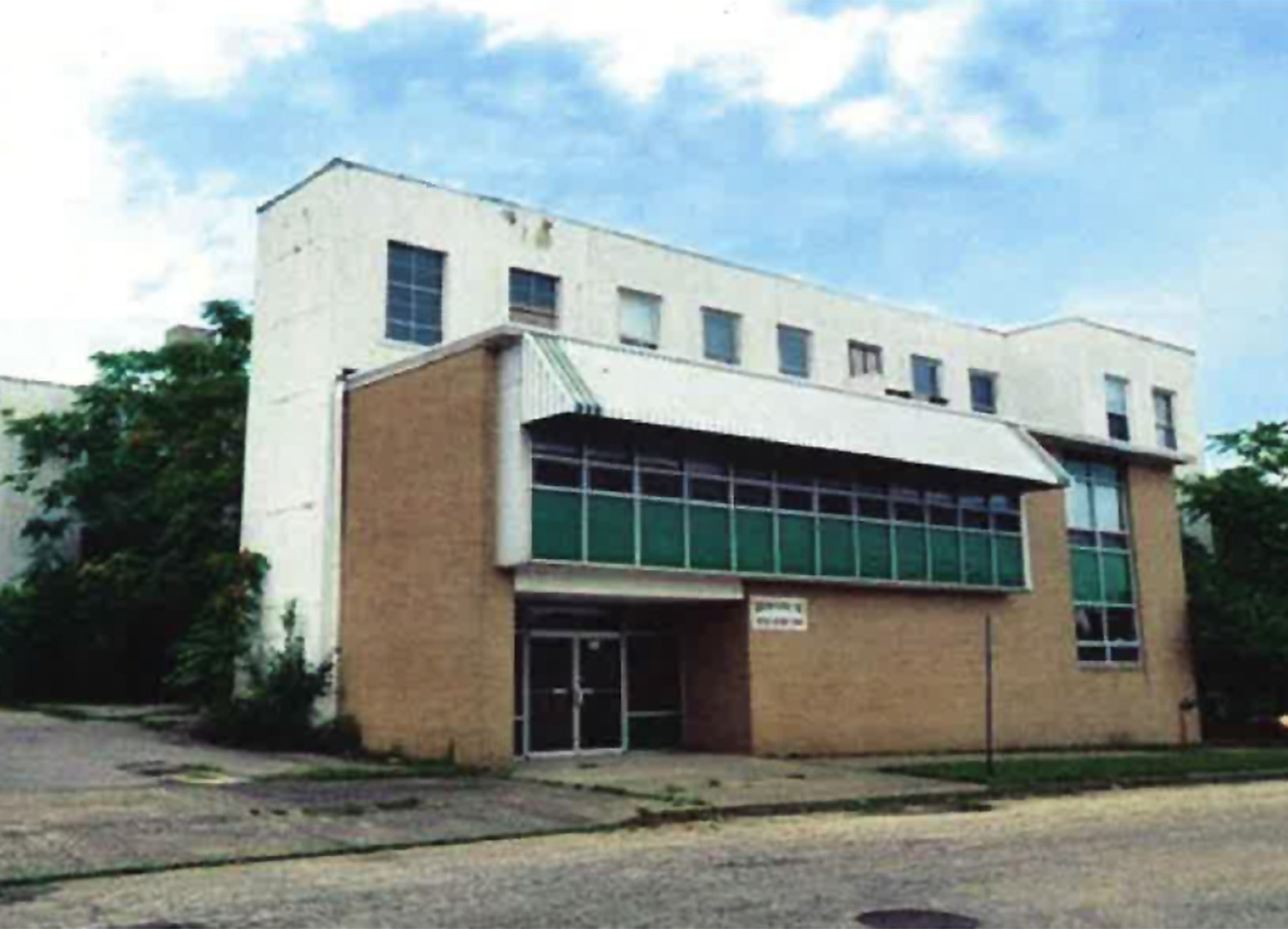 Photo showing the factory in disrepair with trees growing around it