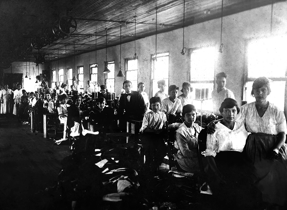 Grayscale photo depicting factory workers in the 1920s.