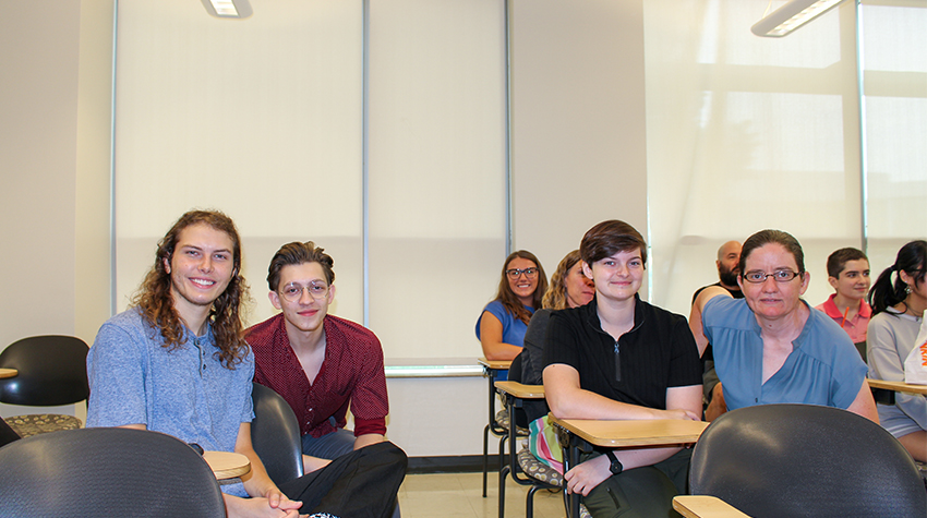 Kaleb and her team for the summer, sitting in chairs in a USC classroom