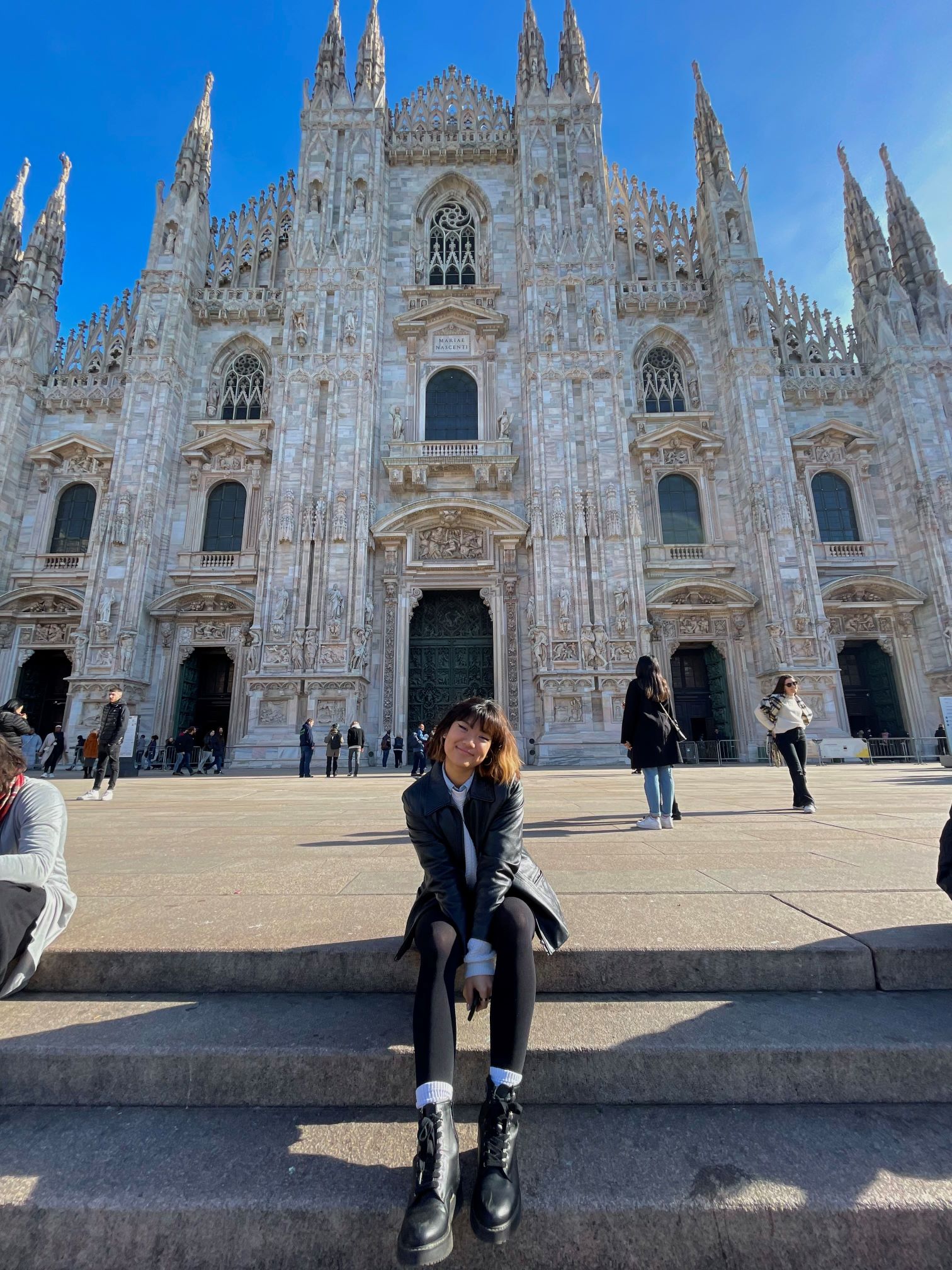 Eline Xia sits in front of the Duomo di Milano in Milan, Italy.