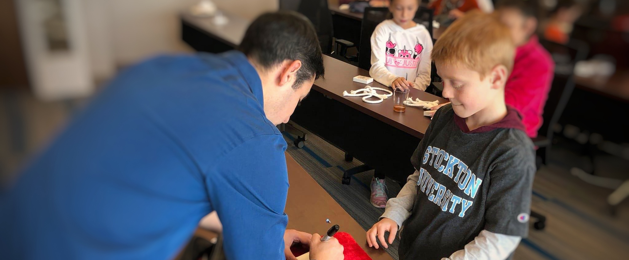 Magician Chad Juros shows Kevin Nugent a magic trick while other alumni and their families practice during the Nov. 10, 2018 “Second Saturdays in Atlantic City.”