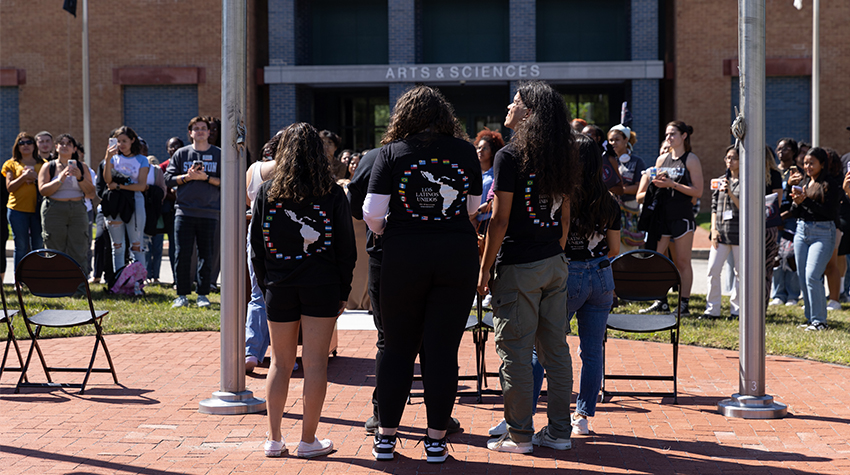 Members of LLU looking up at the flag being hoisted up
