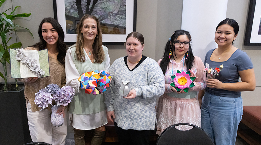 Boakes and students holding paper flowers