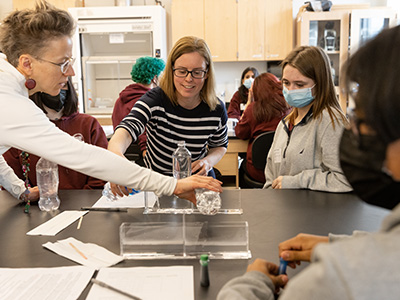 Two professors demonstrating an experiment with students