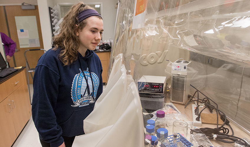 Image of student in front of Coy Anaerobic Chamber