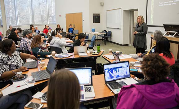 woman speaking to group of adults in classroom