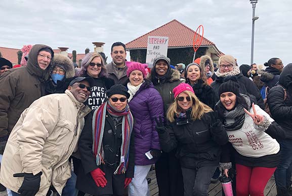 group of women and men smiling outside 