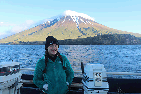 women smiling outside with and water mountain in background