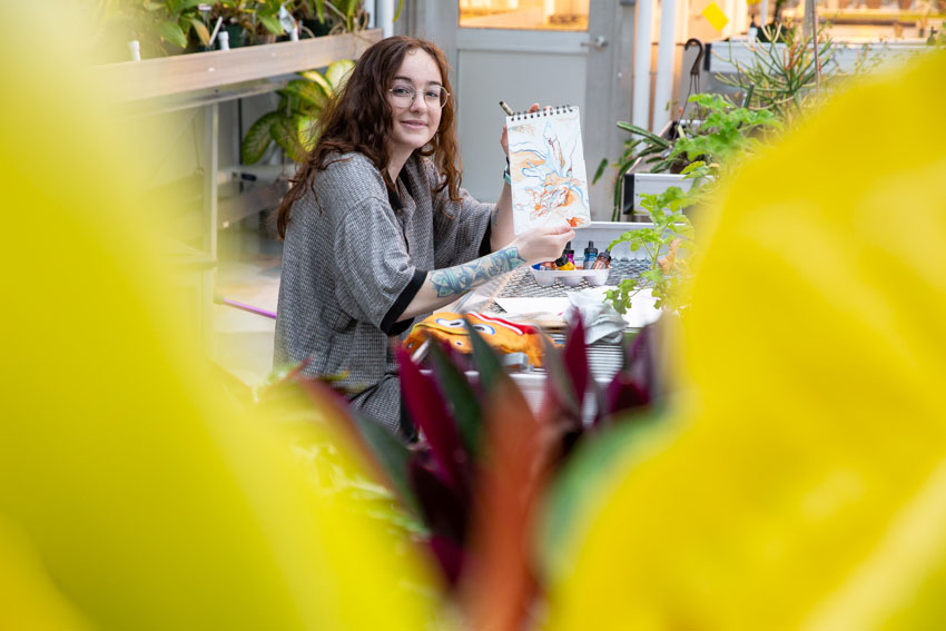 girl smiling through foliage 