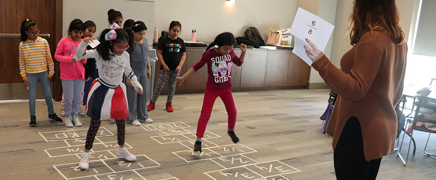 children playing with Stockton students 