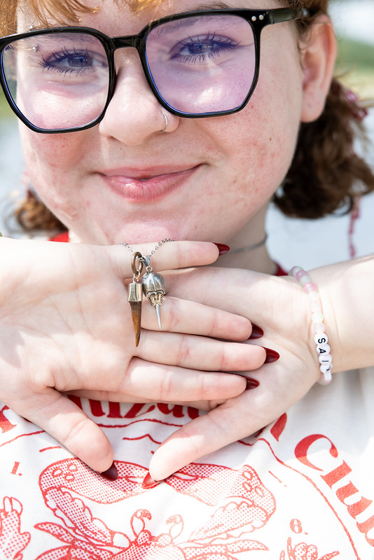 girl holding up charms on necklace World Ocean Day