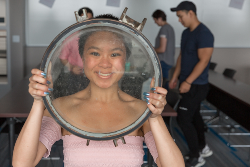 Student peering through porthole window