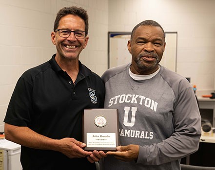 Award recipient Rosado, left, stands with James Gwathney