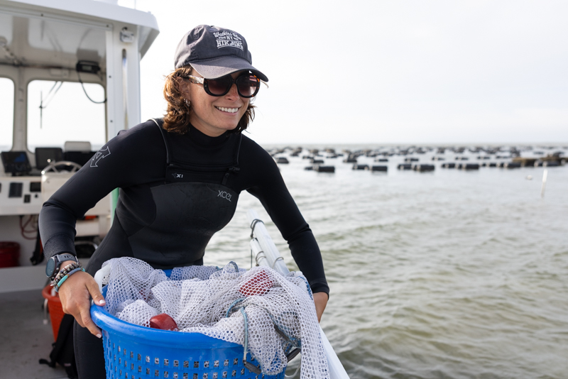 Paige Baney passes a seine net overboard for fellow students