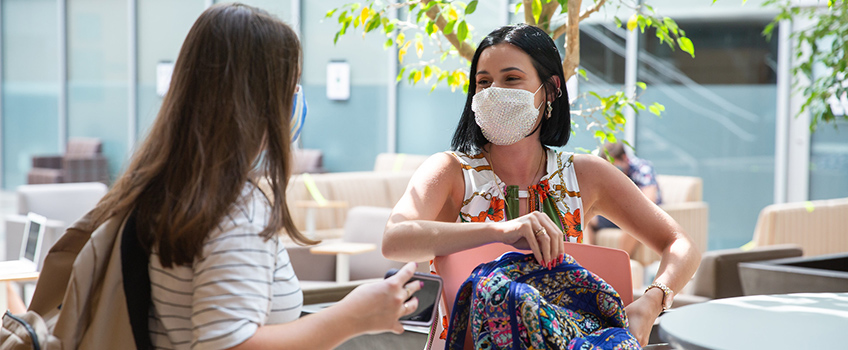 Two students on campus wearing masks