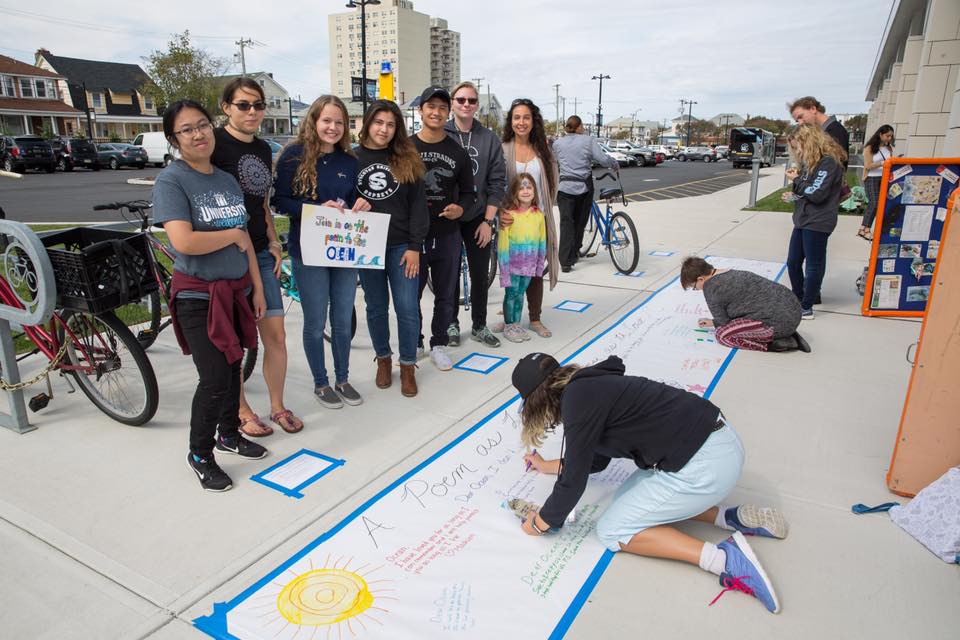 people working on poem on sidewalk 