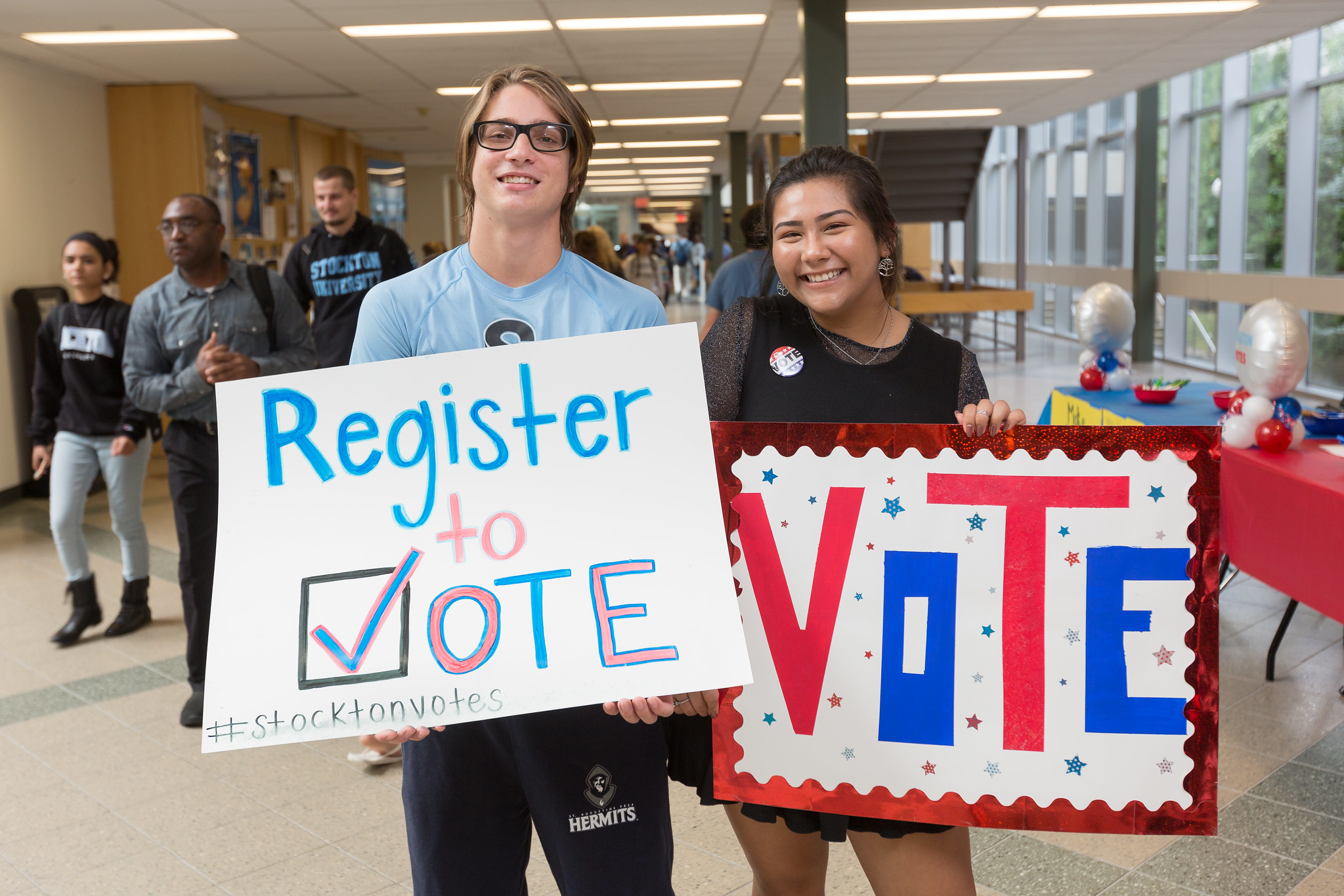 two students holding voting signs 