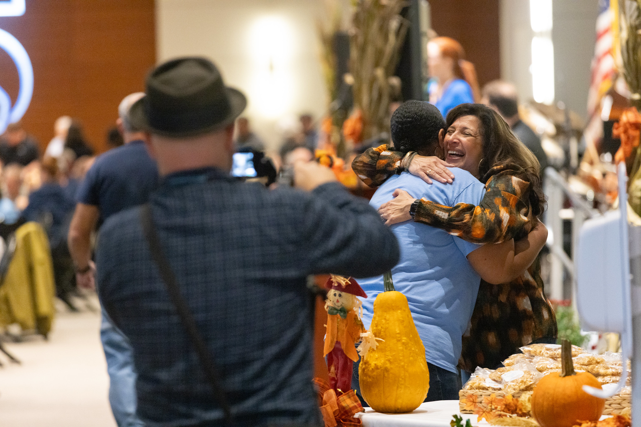 man taking photo of people hugging