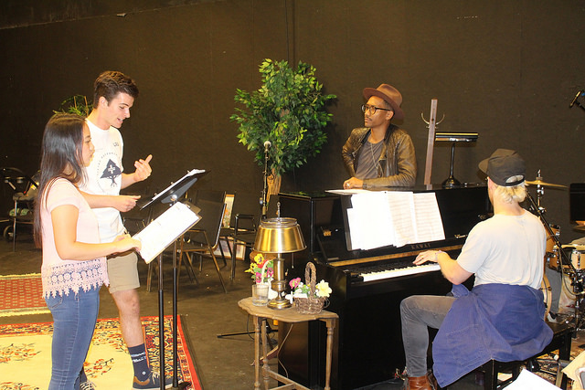 man playing piano for students