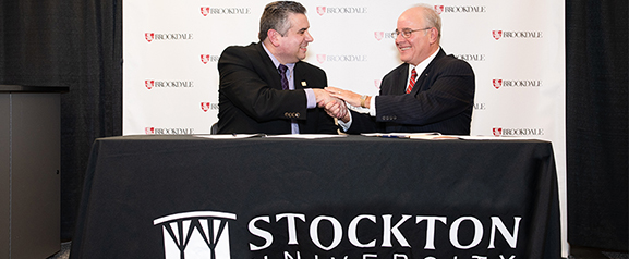 Brookdale Community College President David Stout and Stockton President Harvey Kesselman sign the agreement at Brookdale.